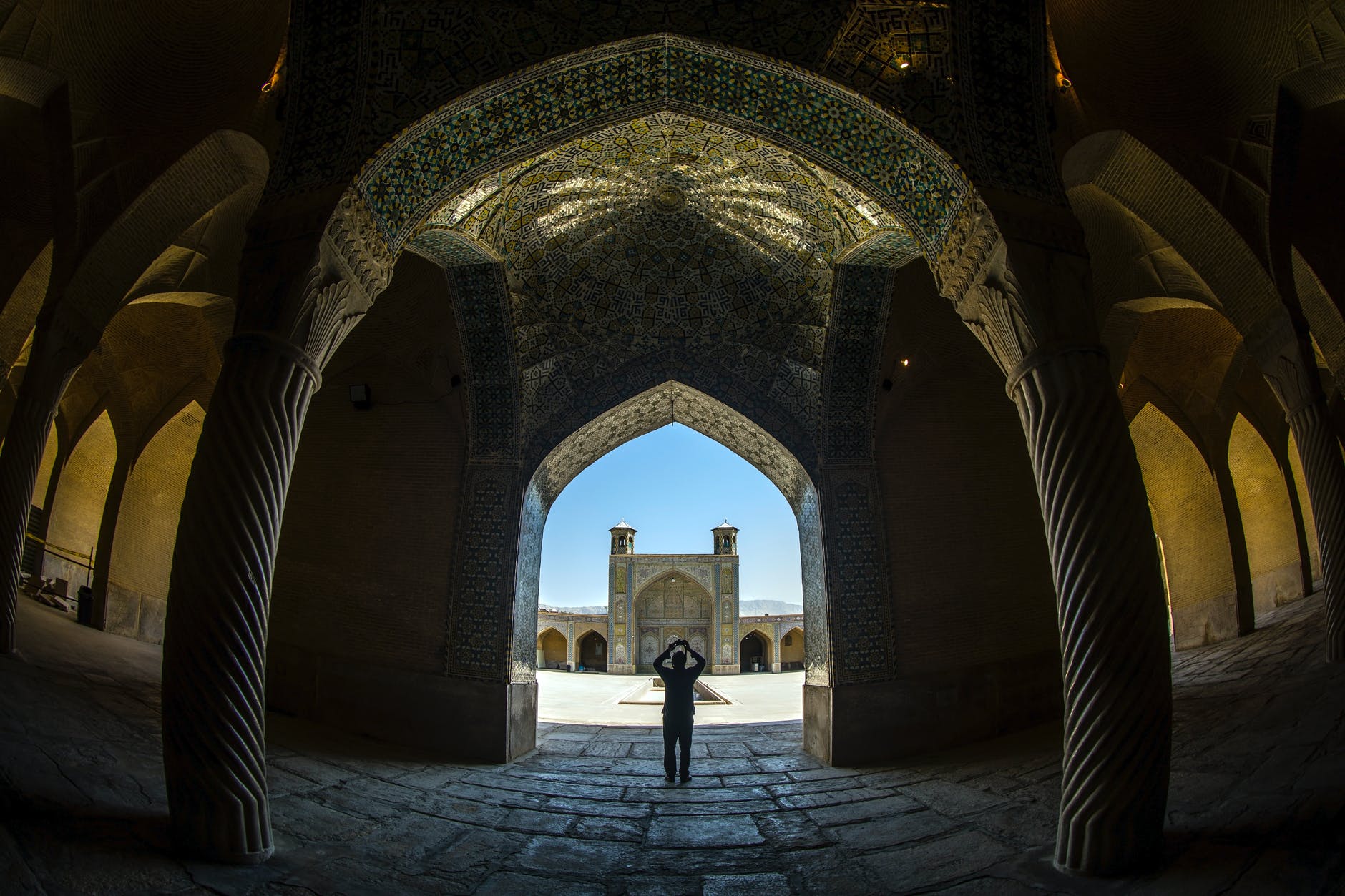fisheye shot of a person inside a building with columns and ornate ceiling